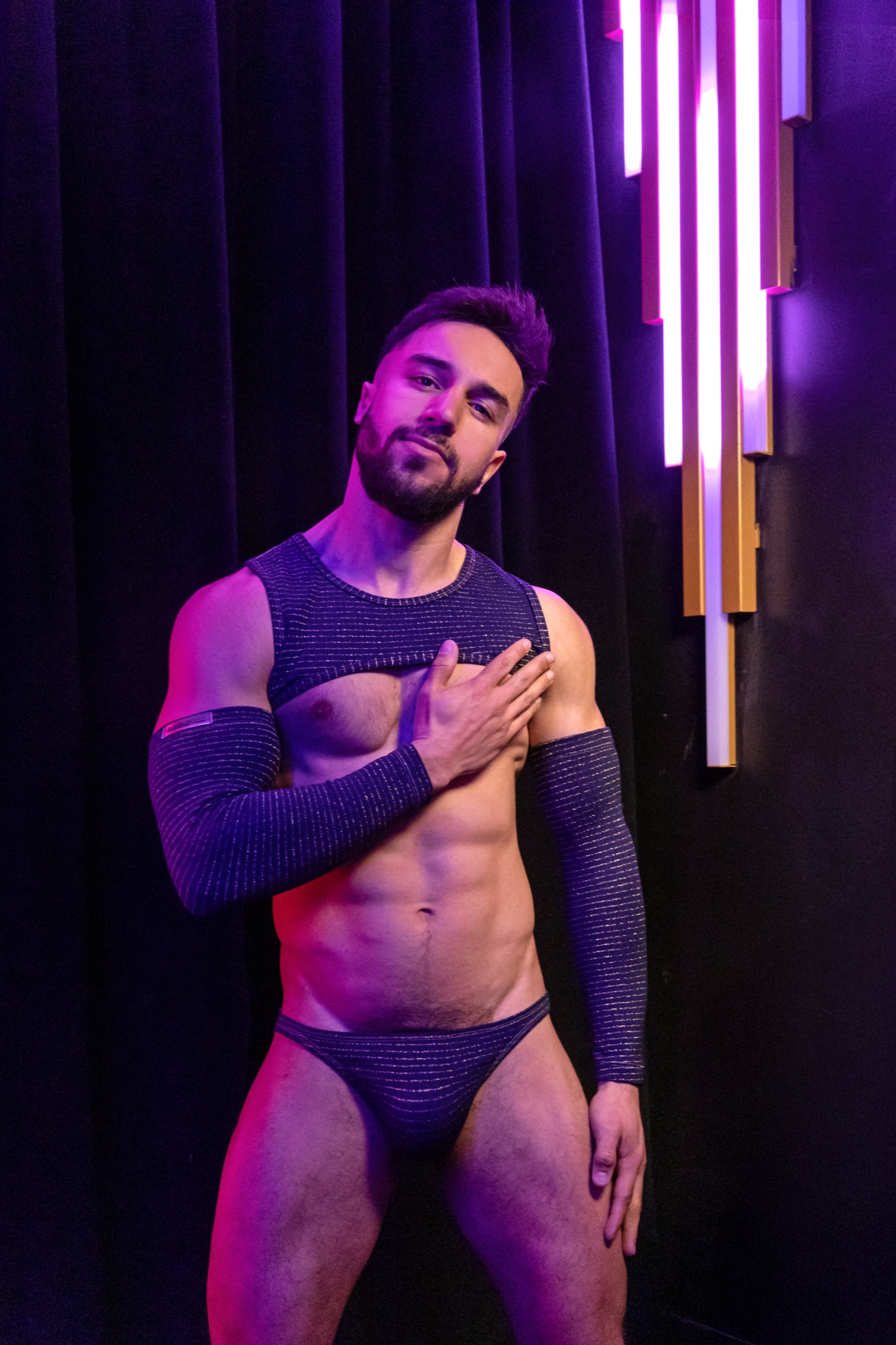 Two ADDICTED models in vivid neon clubwear against a dark background