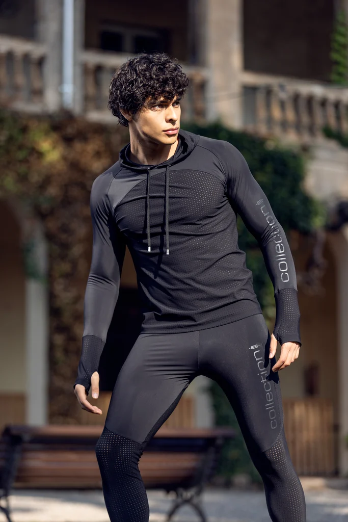 ES Collection model wearing a fitted black tracksuit in an evening courtyard