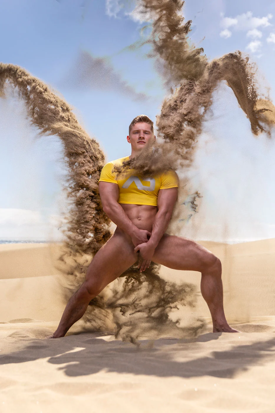 ADDICTED model wearing yellow sportswear as sand moves through the frame