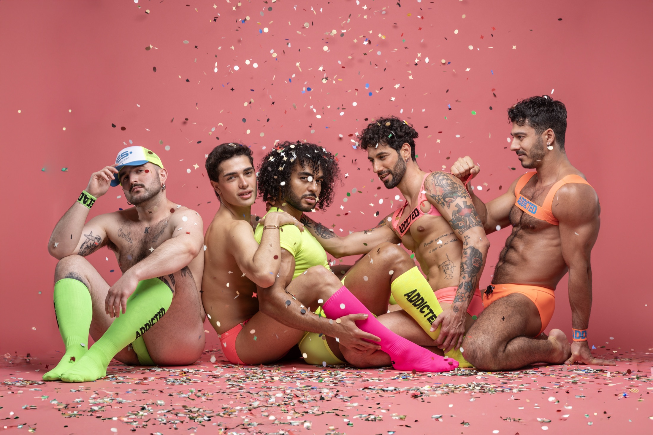 Five ADDICTED models in bright Pride looks surrounded by confetti
