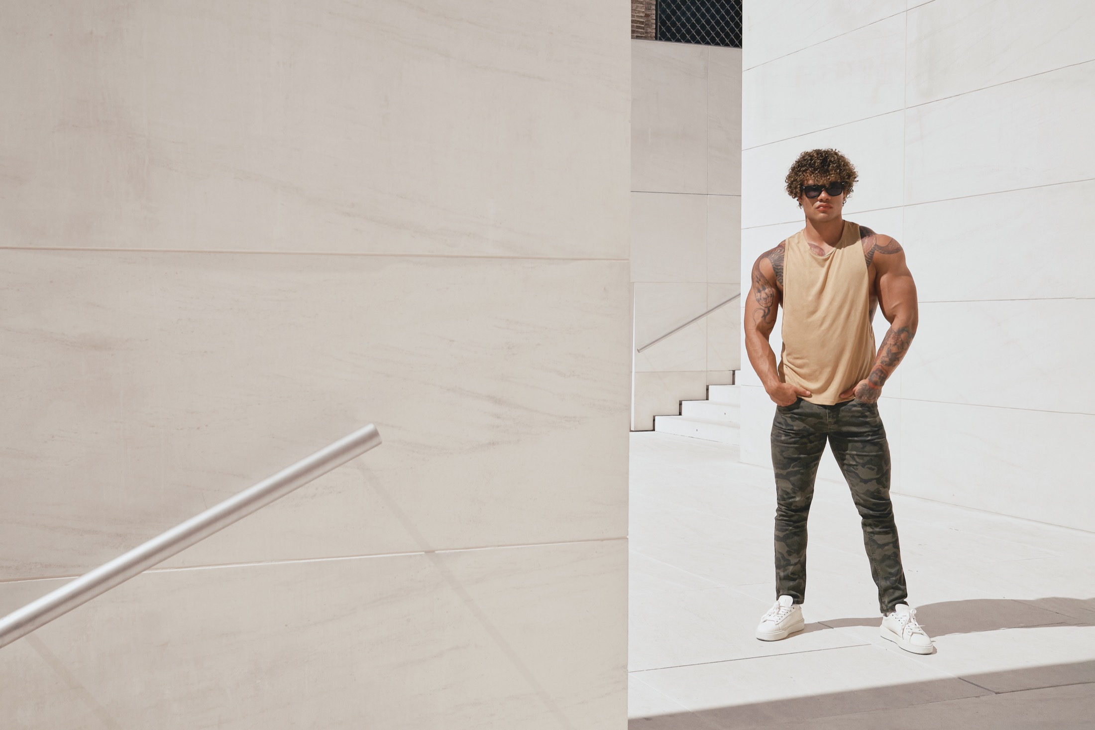 Model in a beige ADDICTED tank top and camouflage trousers in Barcelona